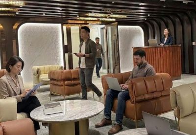 Spacious communal lounge featuring leather armchairs, marble coffee tables, and a reception desk.