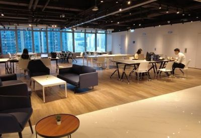 Spacious communal lounge featuring sofas, coffee tables, and wood-style flooring.