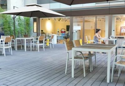 Spacious outdoor terrace with wooden decking, white tables, and large parasols.