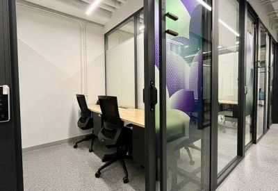 Internal two-person office suite with black ergonomic chairs and glass partitions.