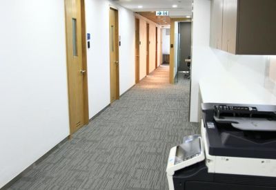 Long hallway featuring several private office doors and grey carpet.