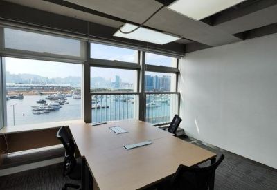 Bright conference room with large windows overlooking a harbor and marina.