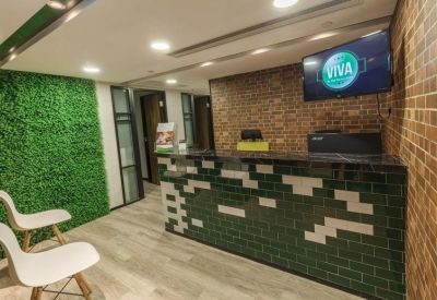 Reception desk featuring a green moss feature wall and brick accents.