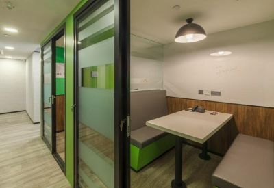 Private meeting booth with green bench seating and a small table.