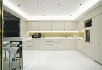 Sleek all-white pantry and kitchen area with modern cabinetry and bar seating.