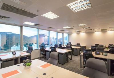 Open-plan workspace with multiple desks, ergonomic chairs, and large windows with city views.