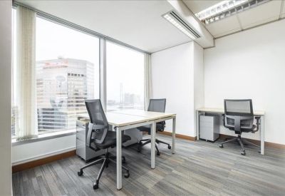 Bright corner office with two desks and a large window overlooking the city.
