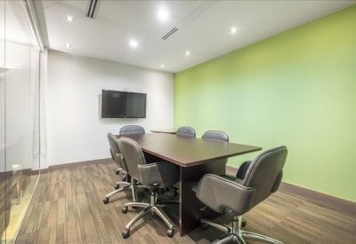 Modern conference room with a dark wood table and a lime green feature wall.