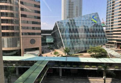 City view through office windows showing contemporary glass architecture and an elevated walkway.