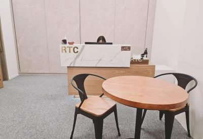 Bright reception area featuring a marble-style desk with RTC branding and a small meeting table.