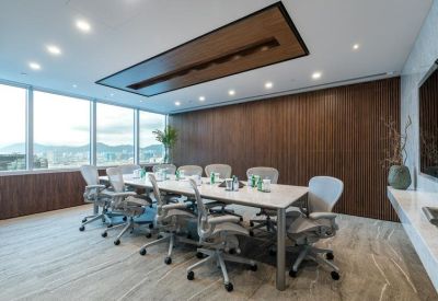 High-end boardroom with a white marble table, ergonomic mesh chairs, and harbor views.