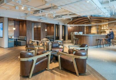 Sophisticated bar and lounge area featuring leather armchairs and dark wood paneling.