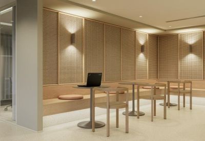 Communal breakout area featuring café-style seating and warm wall sconces.