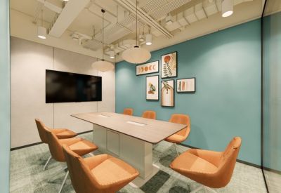 Contemporary meeting room with orange chairs and a gallery wall on a teal background.