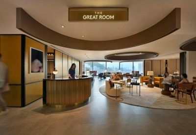 Warmly lit reception area with curved wood paneling and comfortable lounge seating.
