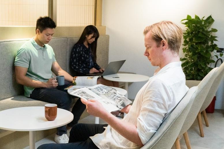 People working and reading in a cozy breakout lounge with soft lighting and plants at 50, Bonham Strand, 2/F, Strand 50.