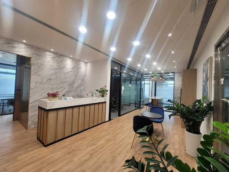 Bright reception area at 10 Shing Yip Street with marble-textured walls and a wooden front desk.