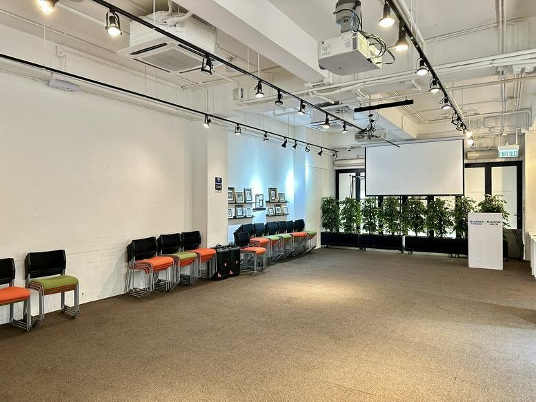 Bright, spacious event space at 118 Wai Yip Street with colorful chairs and a projector screen.
