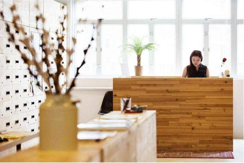 Reception area at Cheung Hing Industrial Building featuring a wooden front desk and natural light.