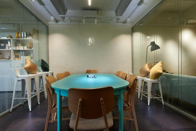 Bright meeting room with a turquoise table and wooden chairs at 141 Connaught Road West, 2/F BUPA Centre.
