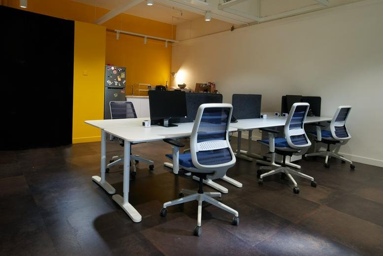 Modern open-plan workspace at 141 Connaught Road West, 2/F BUPA Centre with ergonomic chairs and white desks.