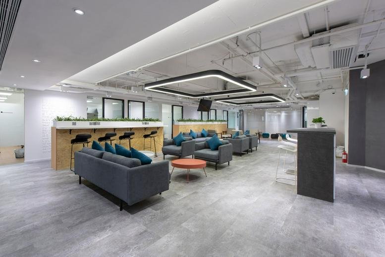 Spacious communal lounge and breakout area at New World Tower with grey sofas and modern lighting.