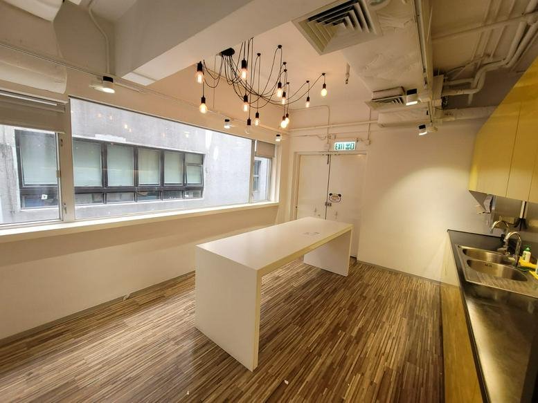 Spacious break area at Hong Kong Spinners Industrial Building Phase 5 with a white island and pendant lighting.