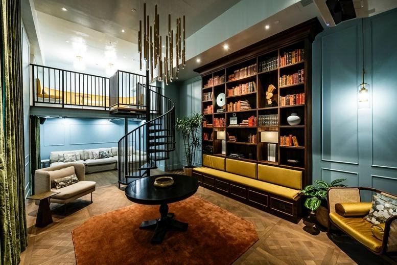 Lounge at Eastern Harbour Centre with spiral staircase, bookshelves, and unique lighting.