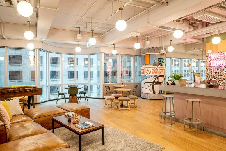 A wide view of a modern cafe-style lounge with diverse seating and a bar counter.