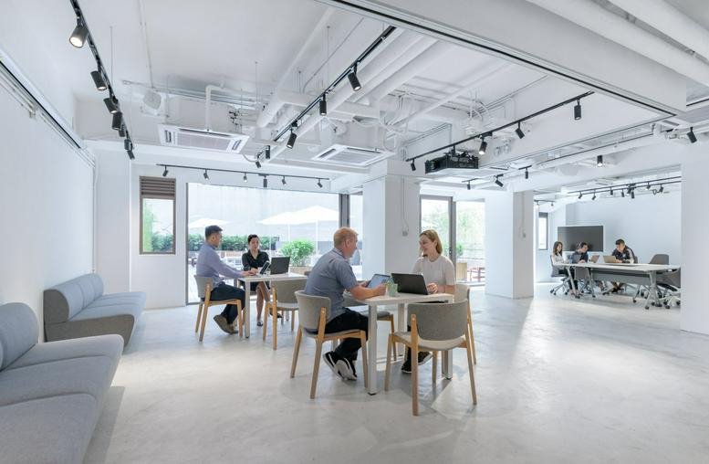 Spacious open-plan common area at Strand 50 with flexible seating and track lighting.