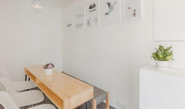Minimalist dining area at 505 Hennessy Road, 15/F Radio City with light wood table and white chairs.