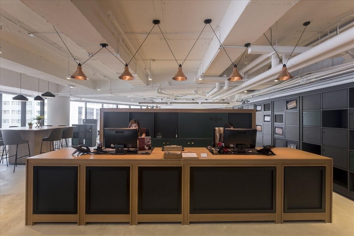Sleek reception area with a long wooden desk and industrial-style lighting.