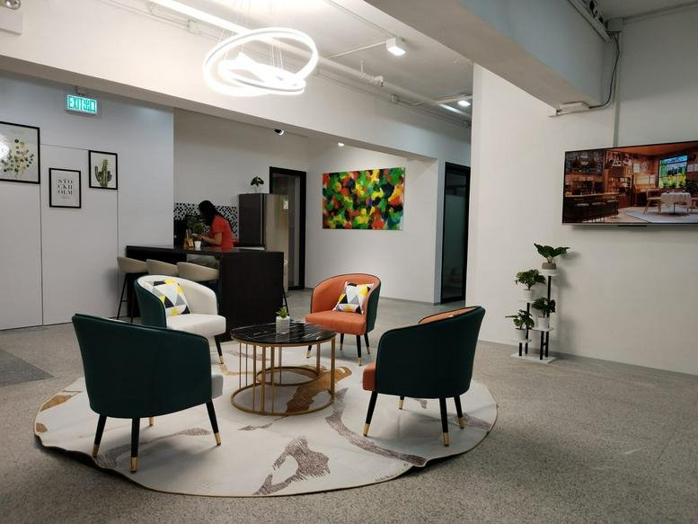Common room at 9/F Kato Factory Building with colorful seating and an artistic rug.