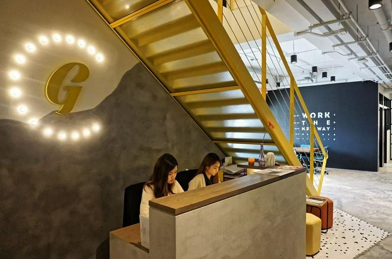 Arion Commerical Centre reception desk with warm wood accents and a bright circular logo.