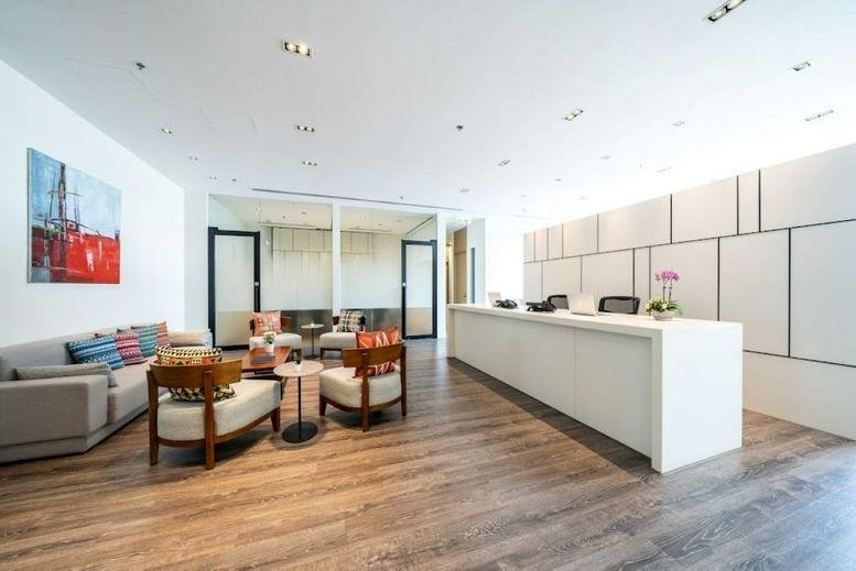 Modern reception area at Billion Plaza II with a white minimalist desk and light wood floors.