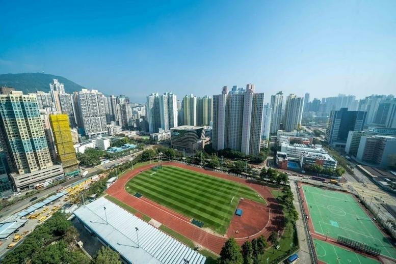 Aerial view of Billion Plaza II surrounded by a dense urban skyline and a green sports field.