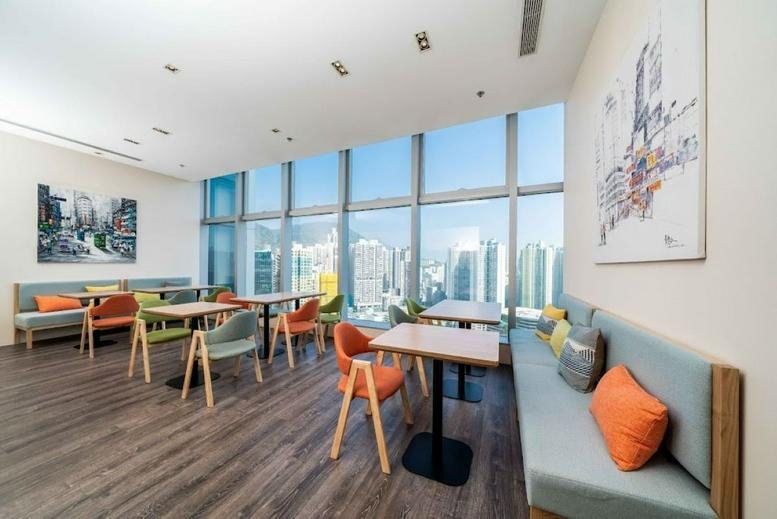 Spacious communal dining area with colorful chairs and city skyline views.
