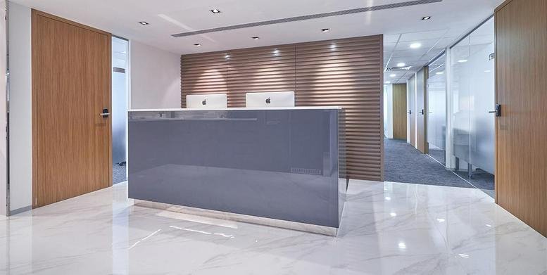 Minimalist reception area at BOC Group Life Assurance Tower featuring a sleek grey desk and wooden accents.