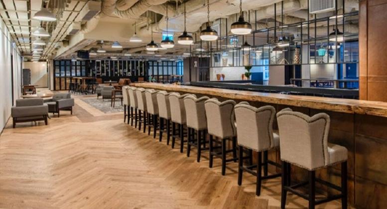 Spacious communal lounge at Champion Tower, 3 Garden Road featuring a long wooden bar and parquet flooring.