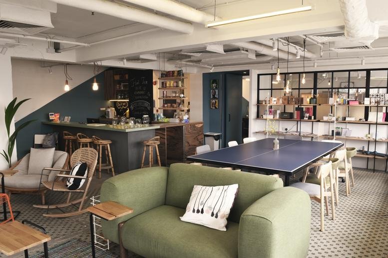 Spacious communal lounge at Chung Kiu Commercial Building featuring a green sofa and café-style bar area.