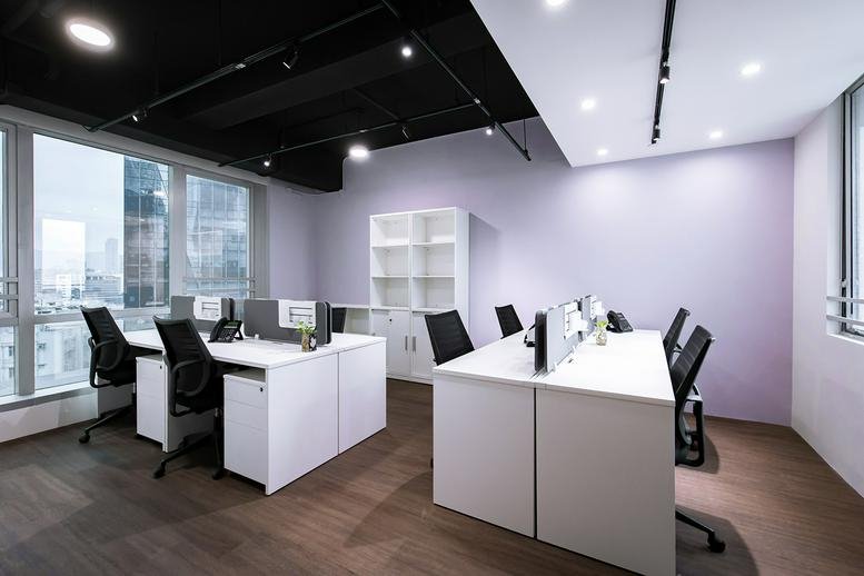 Spacious open-plan workspace at Everglory Centre with modern white desks and city views through large windows.