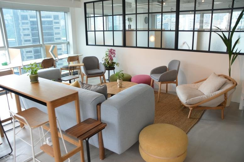 Spacious communal lounge at Honest Building with eclectic seating, a sofa, and natural light.