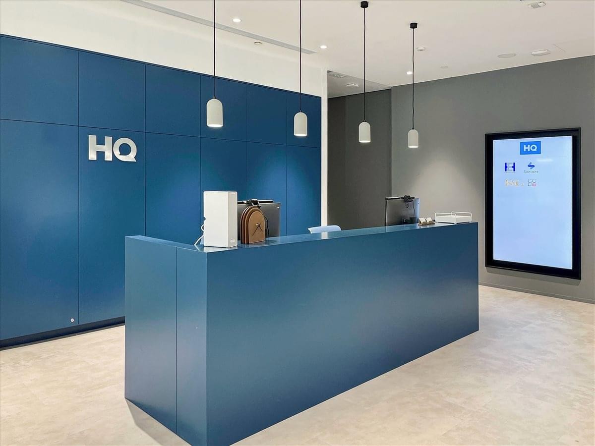 Reception area at K11 Atelier, 728 King’s Road with a blue feature wall and modern pendant lighting.