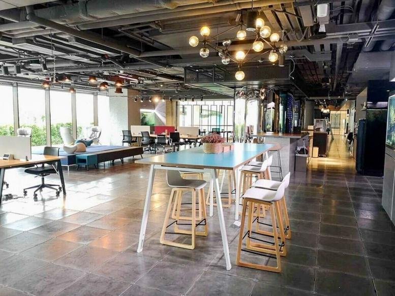 Spacious communal lounge at Kerry Hotel, 38 Hung Luen Road, with modern lighting and a large teal table.