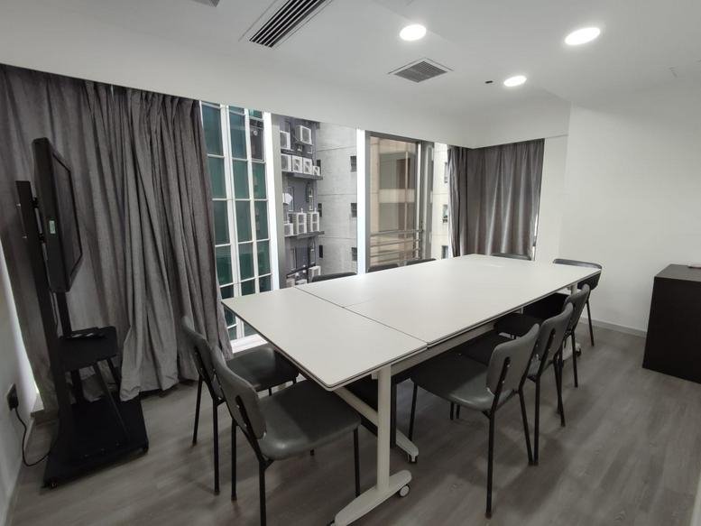 Spacious boardroom with a large white table, seating for eight, and city views at Kyoto Plaza.
