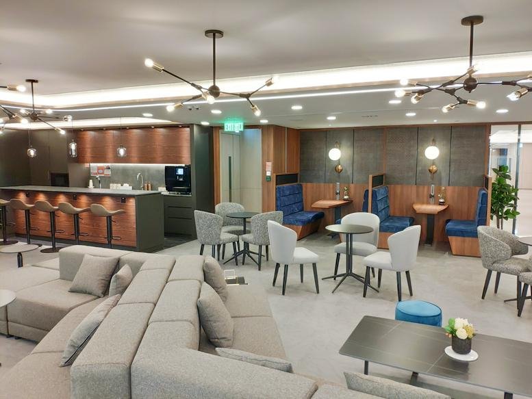 Communal lounge with a variety of seating, a bar area, and modern light fixtures.