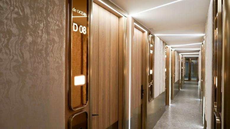 Modern hallway at Mai Tak Industrial Building featuring wooden doors and integrated LED light strips.