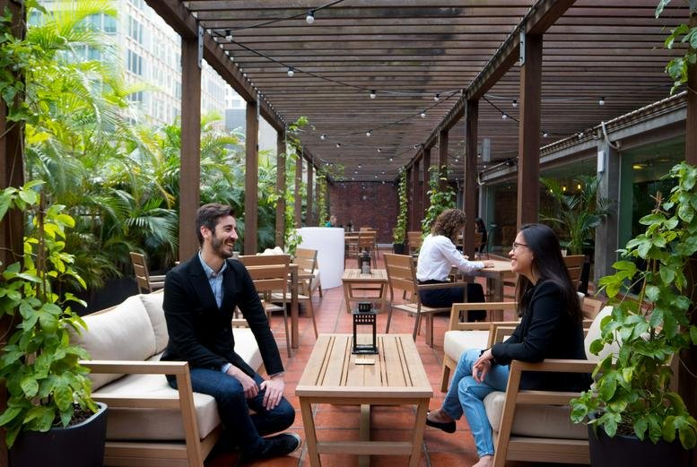 Spacious wooden outdoor terrace with lounge seating and plants at Manning House, 38-48 Queens Road Central.