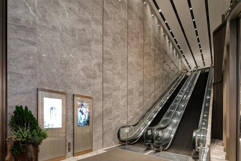 Grand lobby entrance at New World Tower 1 featuring marble walls and escalators.