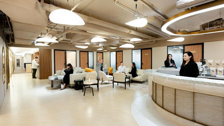 Bright open-plan coworking space with modern pendant lighting and lounge seating.